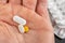 Medical tablets on a male hand. Medication on a dark table