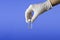 Medical theme: a doctor`s hand in a white medical glove holds a vial of injection medicine or coronavirus vaccine. side view.