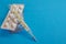 Medical thermometer and white pills on a blue background