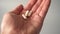 Medical white capsules fall into the palm of your hand
