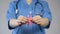 Medical worker in blue uniform holding pink ribbon in hands, breast cancer risk