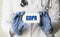 A medical worker  in gloves holds a card with the words GDPR General Data Protection Regulation. Medical concept