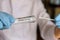 Medical worker holding swab sample collection kit, test tube for performing patient nasal swabbing. Hands in gloves holding