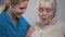 Medical worker presenting elderly lady birthday cake, taking care and support