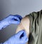 Medical worker putting band aid on male upper arm after covid 19 vaccine shot