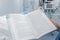 Medical worker reads book on his post at the patient`s bedside