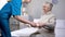 Medical worker serving dinner to old female patient, taking care of granny