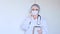 Medical worker in a white coat and a protective mask on a light background. Woman doctor video portrait. Free space for