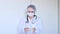 Medical worker in a white coat and a protective mask on a light background. Woman doctor video portrait. Free space for