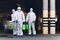 Medical workers in coronavirus hazmats holding spray bottles with disinfecting chemicals