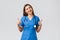 Medical workers, healthcare, covid-19 and vaccination concept. Friendly upbeat female nurse or doctor in blue scrubs