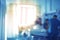 Medical workers at the patient`s bed in a sunlit room, unfocused