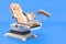 Medicals Gynecological Examination Chair on blue backdrop, 3D rendering