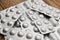 Medicaments on a wooden table. Many tablets in silvery blisters