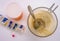 Medication during breakfast, cup of coffee next to a pillbox, conceptual image