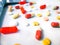 Medication white and colorful tablets arranged abstract on white