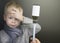 Medicinal syrup in a syringe on the background of a sick boy. Antiviral, anti-inflammatory or antipyretic. The concept of treating