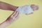 Medicine bandage on injury female hand on yellow background
