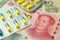 Medicine blister pack on Chinese cash banknotes background. World economy crisis, fix or solution U.S. vs China dispute trade war