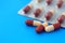 Medicine in capsules and in a tablet on a blue background.