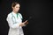 Medicine Concepts. Portrait of Professional Female GP Doctor Posing in Doctor`s Smock and Endoscope. Reading Documents. Against