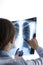 Medicine, Healthcare Ideas. Professional Radiologist Doctor Checking Patient`s Xray Film On White