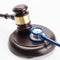 Medicine and medical symbols - close up shot of a wooden judge gavel and a stethoscope