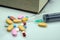Medicine pills, tablets, syringe and book