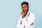 Medicine, profession and healthcare concept. African american male doctor with stethoscope in white coat on blue background