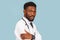 Medicine, profession and healthcare concept. African american male doctor with stethoscope in white coat on blue background