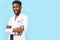 Medicine, profession and healthcare concept. African american male doctor with stethoscope in white coat on blue background