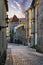 Medieval alley along the stone wall in the city of Tallinn at sunrise.