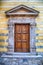 Medieval ancient wooden door with ornate stone columns, Italy.