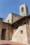 Medieval building with a tower with bells on the street of San Gimignano, Italy