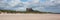 Medieval castle by a beach Bamburgh Northumberland north England UK with white sand panorama