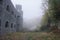 Medieval castle and fort with arch windows in misty and foggy morning on a hill.