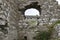 Medieval castle ruins in rural Ireland showing a crumbling window portal