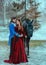 Medieval couple in love man and woman hugging in winter forest. Vintage clothing red long dress. Blue frock coat costume