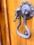 A medieval doorknocker on a wooden door in a Tuscan hill town Italy