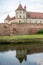 The medieval Fagaras Citadel, dating back to 1310, reflected in its castle moat. FagaraÈ™, Brasov County, Transylvania, Romania