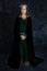 A Medieval and Fantasy woman wearing a green velvet dress and velvet cloak