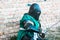 Medieval knight in armor. Green clothes. The historical restoration of military events