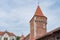 Medieval red brick castle defense watchtower against blue sky