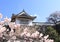 Medieval stone fortress wall, watch tower and blooming sakura branches, Okayama castle, Okayama,