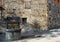 Medieval well with an old stone building on background