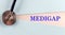 MEDIGAP word made on torn paper, medical concept background