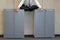 Meditating businessman in lotus pose on cabinets in office