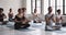 Meditating diverse people seated in lotus pose practicing yoga indoors