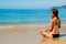 Meditating girl on the beach