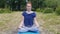 Meditating woman in lotus pose outdoors, female opens eyes after deep meditation